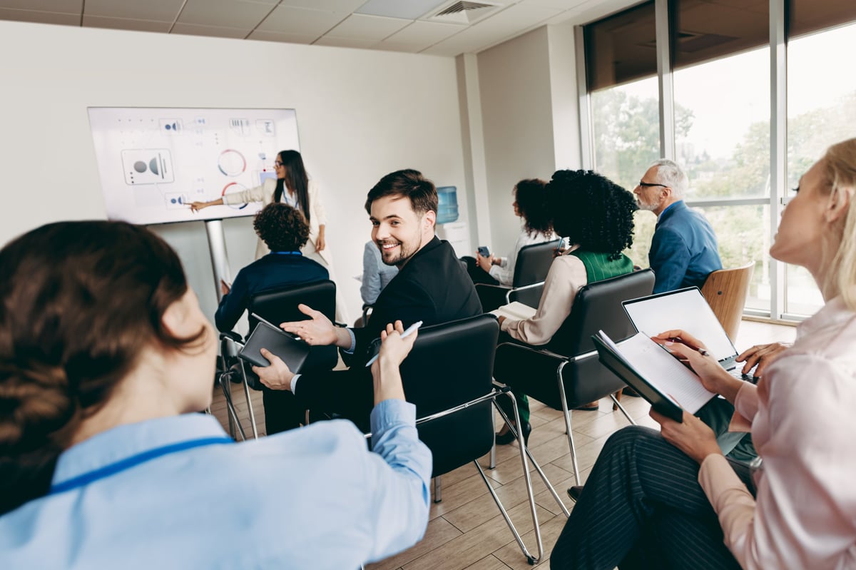 Group of business professionals attending a corporate training session in a modern office, engaging in teamwork and active collaboration.